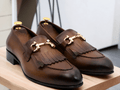 Expertly crafted with real leather, these handmade dark brown fringe horse bit shoes exude stylish luxury and sophistication. A timeless twist on classic men's loafer shoes, these shoes showcase a unique horse bit style that adds a touch of elegance to any outfit. Elevate your shoe game with these unique and refined shoes.