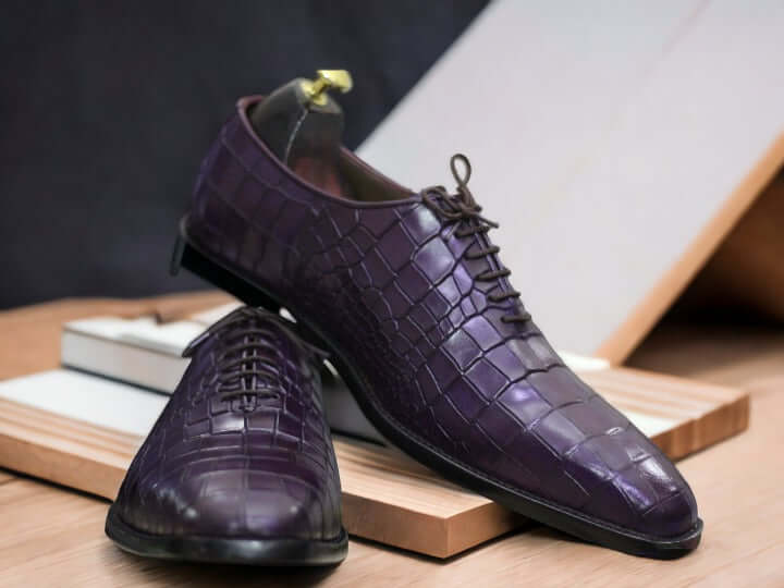 These Purple Alligator Print Leather Oxfords Shoes combine sturdy Italian leather with a classic oxford style for an exquisite look. The alligator print adds a unique style to the classic design, making these shoes the perfect choice for any occasion.