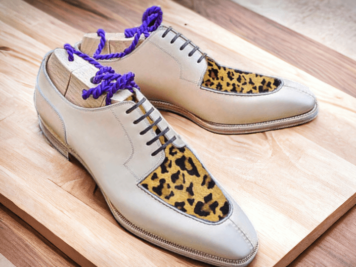 Expertly crafted by hand, our Men's White Leopard Designer Shoes showcase sophistication and style. The unique leopard print design adds a touch of boldness, while the high-quality materials ensure durability and comfort for the wearer. Make a statement with these luxurious, handmade shoes.