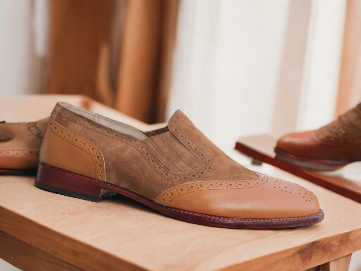 Expertly crafted by hand, these men's brown leather and suede loafers exude both style and comfort. The classic wing tip brogue design adds a touch of sophistication to any outfit, making them the perfect choice for the fashion-forward man. Stand out in these statement shoes that are both fashionable and functional.