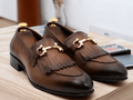 Expertly crafted with real leather, these handmade dark brown fringe horse bit shoes exude stylish luxury and sophistication. A timeless twist on classic men's loafer shoes, these shoes showcase a unique horse bit style that adds a touch of elegance to any outfit. Elevate your shoe game with these unique and refined shoes.