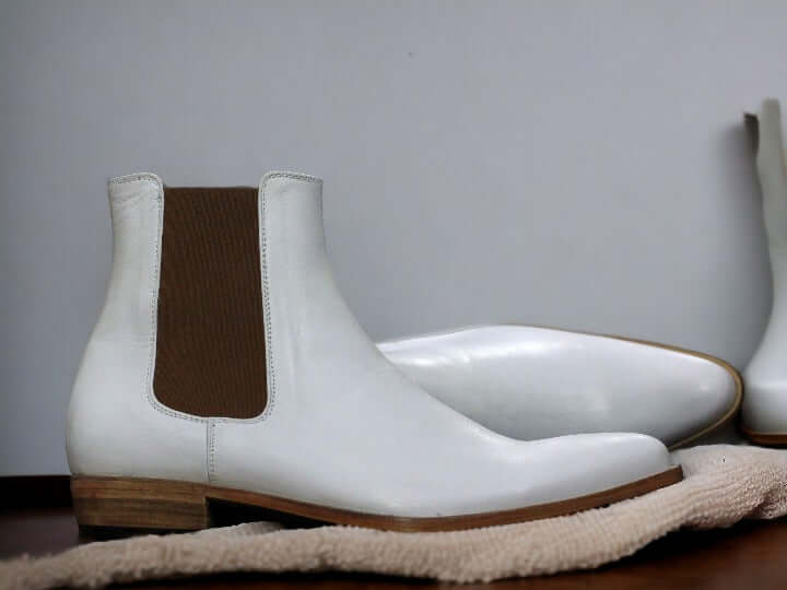 Expertly crafted by hand, our pure white leather boot exudes luxury and style. The sleek design of the men's Chelsea boot adds a touch of sophistication to any outfit. Made from genuine leather, it's a durable and high-quality addition to your wardrobe. Elevate your fashion game with this must-have luxury boot.