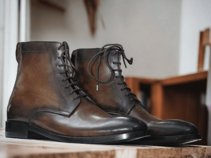 This men's boot is crafted with vintage leather and hand-painted for a unique design. It features a classic lace-up style with a sturdy rubber sole for a durable wear. Perfect for a timeless, stylish look.