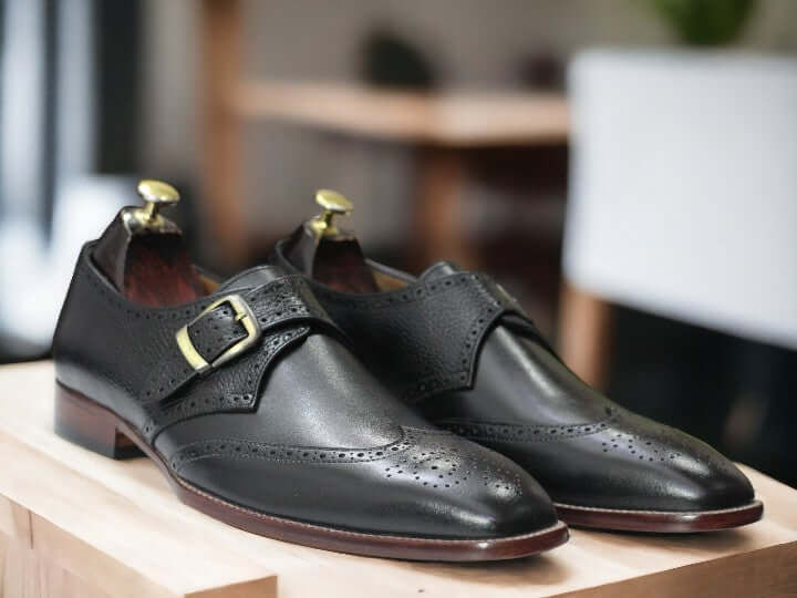 These men's black monk strap shoes are handcrafted with stylish single straps, perfect for office wear. Their classic design and high-quality leather make them a comfortable and fashionable choice. Upgrade your business attire with these functional and sleek buckle shoes.