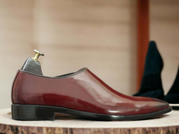 These Men's Maroon Patent Chelsea Shoes are handcrafted from high-quality leather, providing a polished and sophisticated look suitable for any dressy occasion. Featuring the classic Chelsea style with a sleek patent finish, these shoes are sure to elevate any outfit. Perfect for any fashion-forward man looking to make a statement.