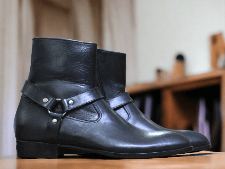 This ankle-high black leather Madrid boot from our men's collection offers a stylish and secure fit with its side zipper closure and adjustable Madrid strap. Crafted from quality materials, it's guaranteed to last.