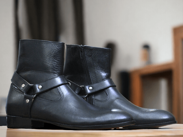 This ankle-high black leather Madrid boot from our men's collection offers a stylish and secure fit with its side zipper closure and adjustable Madrid strap. Crafted from quality materials, it's guaranteed to last.