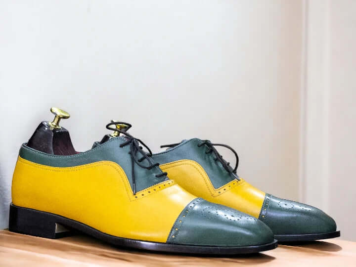 Expertly crafted with high-quality leather, these handmade Green Yellow Oxfords feature a stylish cap toe design. Elevate your wardrobe with these designer shoes that are perfect for any occasion. Enjoy the unique combination of green and yellow, making these Oxfords stand out from the rest.