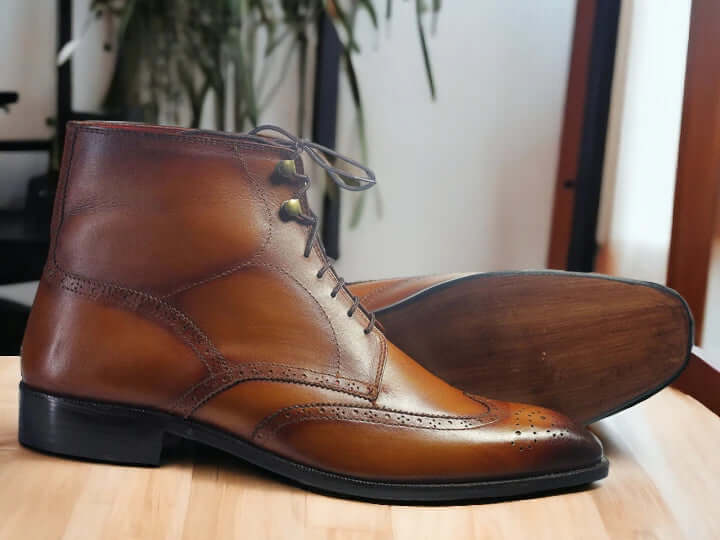 Step out in style with our Men's Ankle High Wing Tip Dress Boots, seamlessly blending classic and fashionable aesthetics. Crafted from brown leather, these boots not only elevate your style but also provide essential ankle-high support. Whether it's a formal event or a dressy occasion, these boots are a must-have for the fashion-forward man