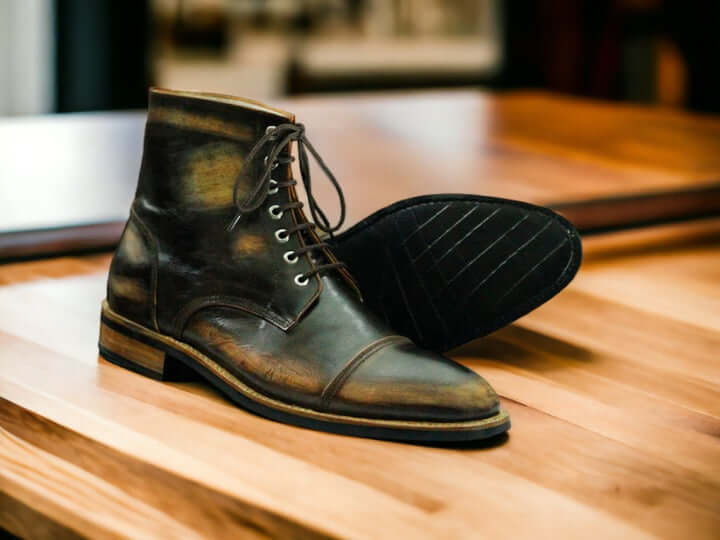 Expertly crafted with bespoke handmade rub off leather, these brown exotic cap toe boots are the epitome of luxury and style. Made with a Goodyear welt construction, you can count on these ankle high boots for superior durability and comfort. Elevate your wardrobe with these exquisite boots.