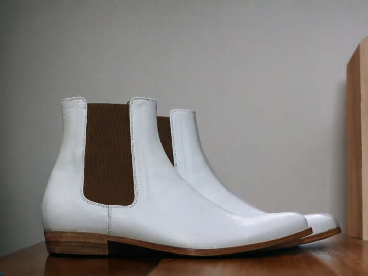 Expertly crafted by hand, our pure white leather boot exudes luxury and style. The sleek design of the men's Chelsea boot adds a touch of sophistication to any outfit. Made from genuine leather, it's a durable and high-quality addition to your wardrobe. Elevate your fashion game with this must-have luxury boot.