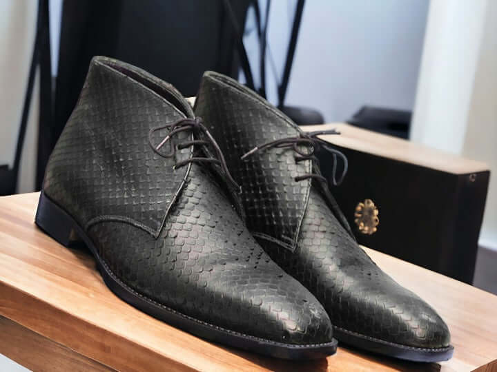 Expertly crafted with sleek black python leather, these handmade chukka boots are a sophisticated addition to any man's wardrobe. The exotic leather not only adds a touch of luxury, but also provides durability for long-lasting wear. Elevate your style with these unique and timeless boots.