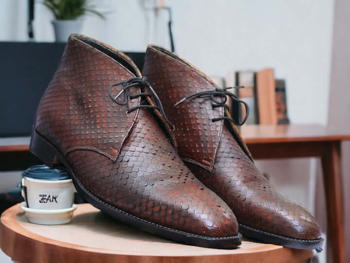 Expertly crafted with sleek black python leather, these handmade chukka boots are a sophisticated addition to any man's wardrobe. The exotic leather not only adds a touch of luxury, but also provides durability for long-lasting wear. Elevate your style with these unique and timeless boots.